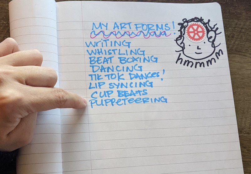 A list of art forms handwritten on a page of a notebook