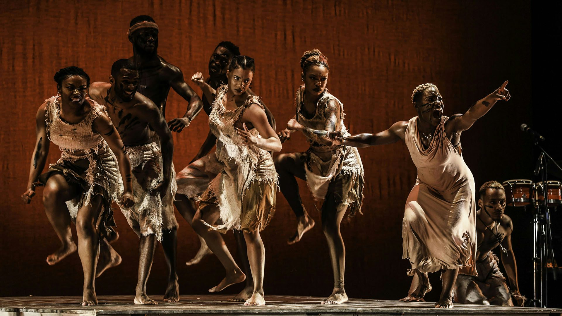 A group of Step Afrika's dancers, mid-dance, are full of passionate rage, pointing and stomping.