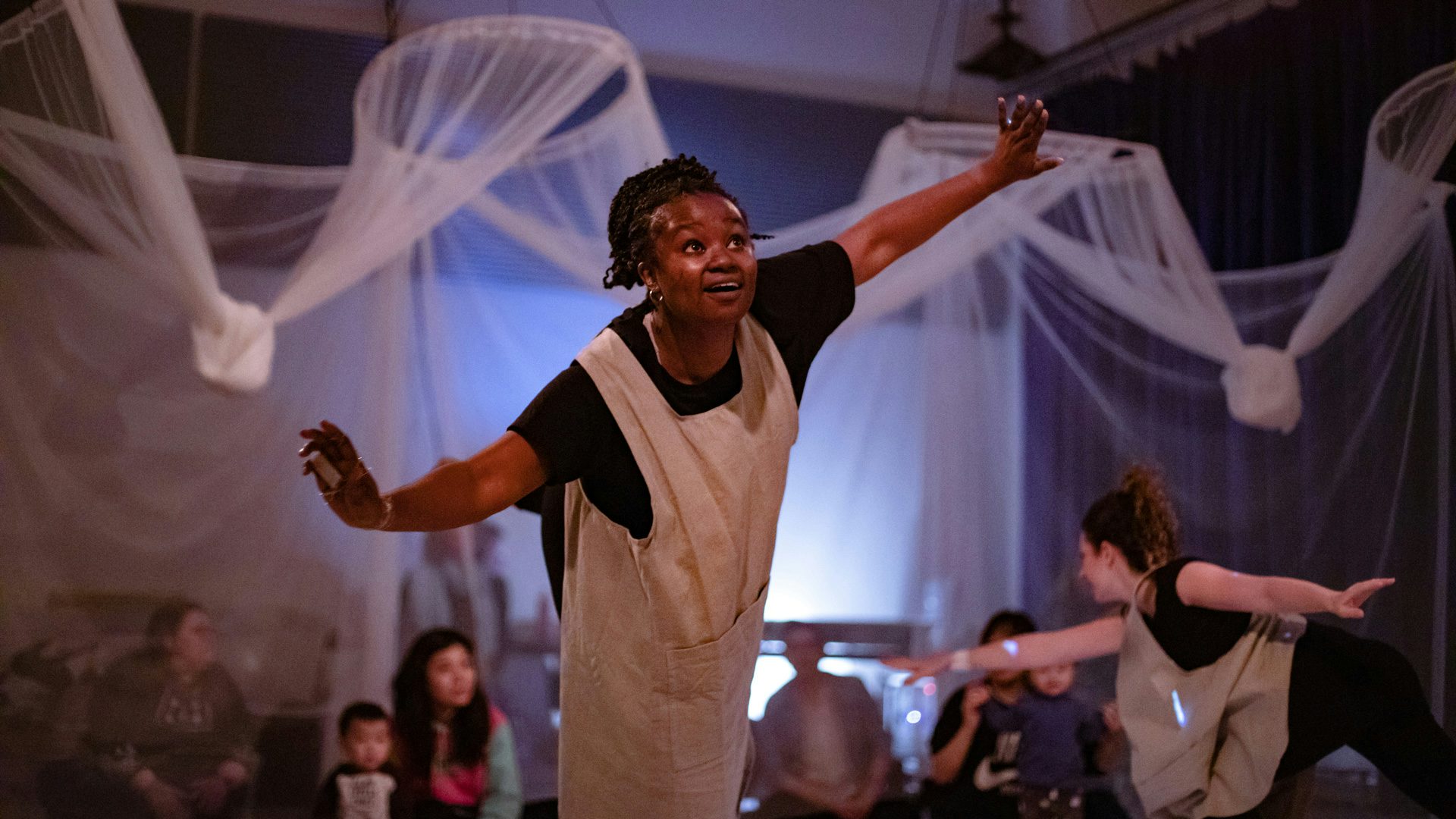 An actress spreads her arms wide open, like an airplane.