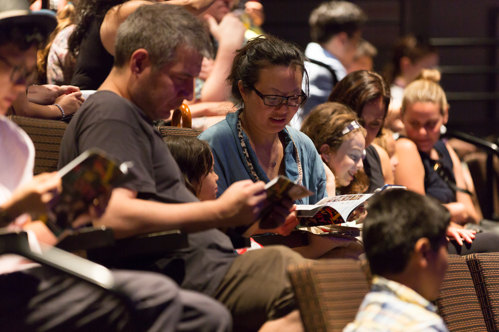 A group of audience members review their show programs.