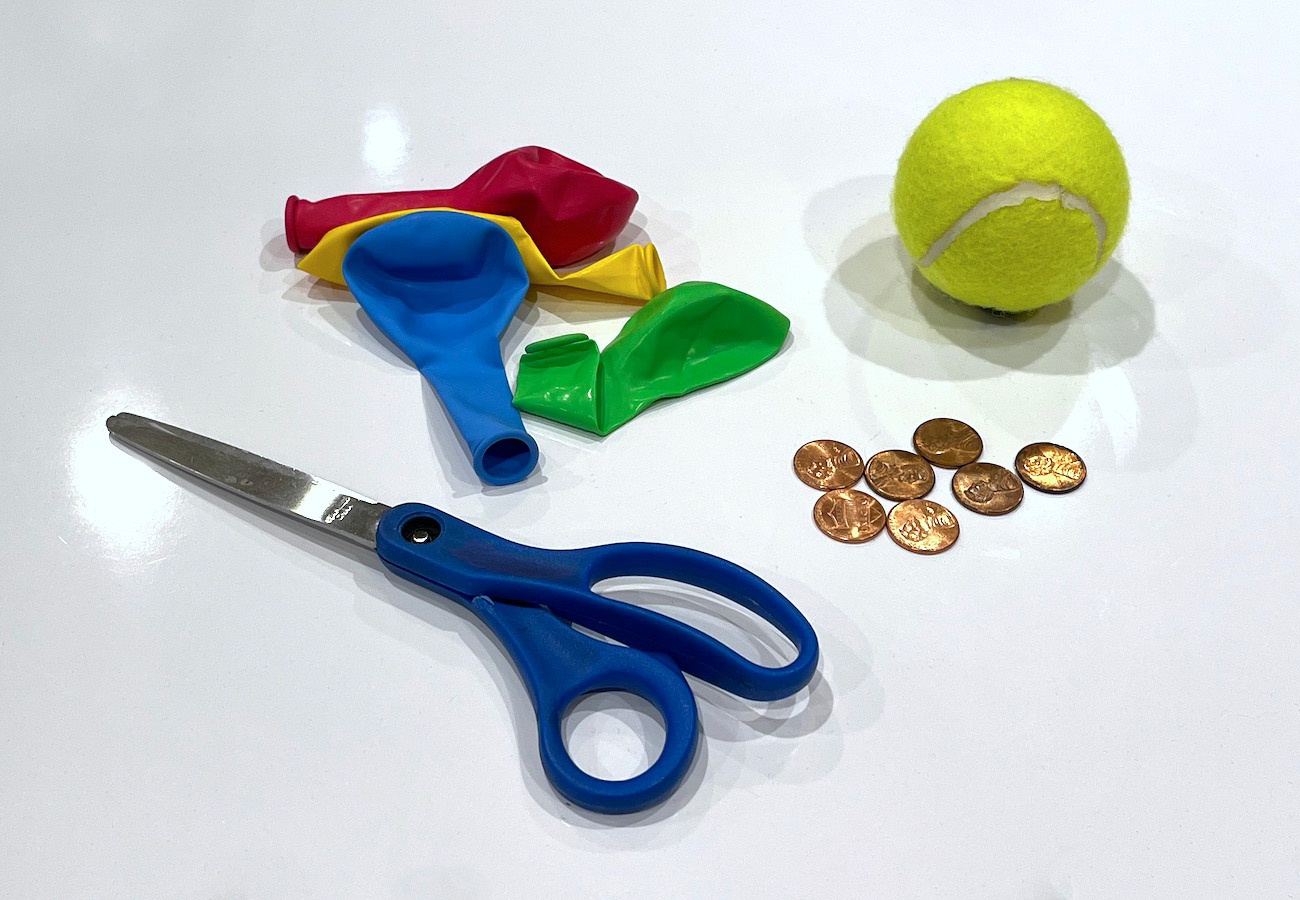Uninflated balloons, tennis balls, pennies, a pair of scissors