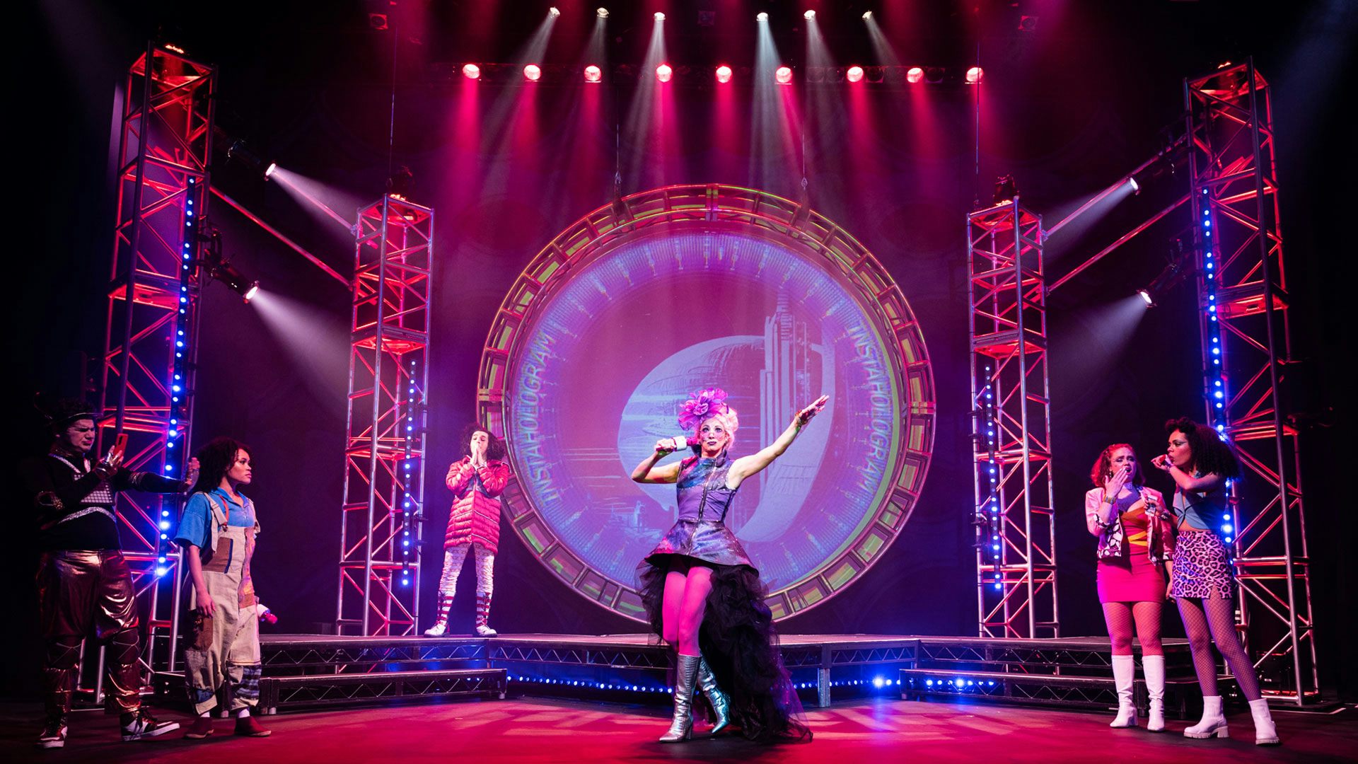 The cast of Hip Hop Cinderella on stage during a musical number with pink and purple lights.
