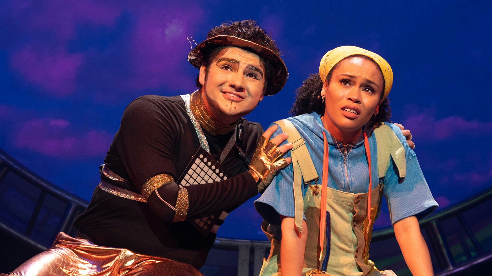 A man dressed as a robot consoles a woman on stage.