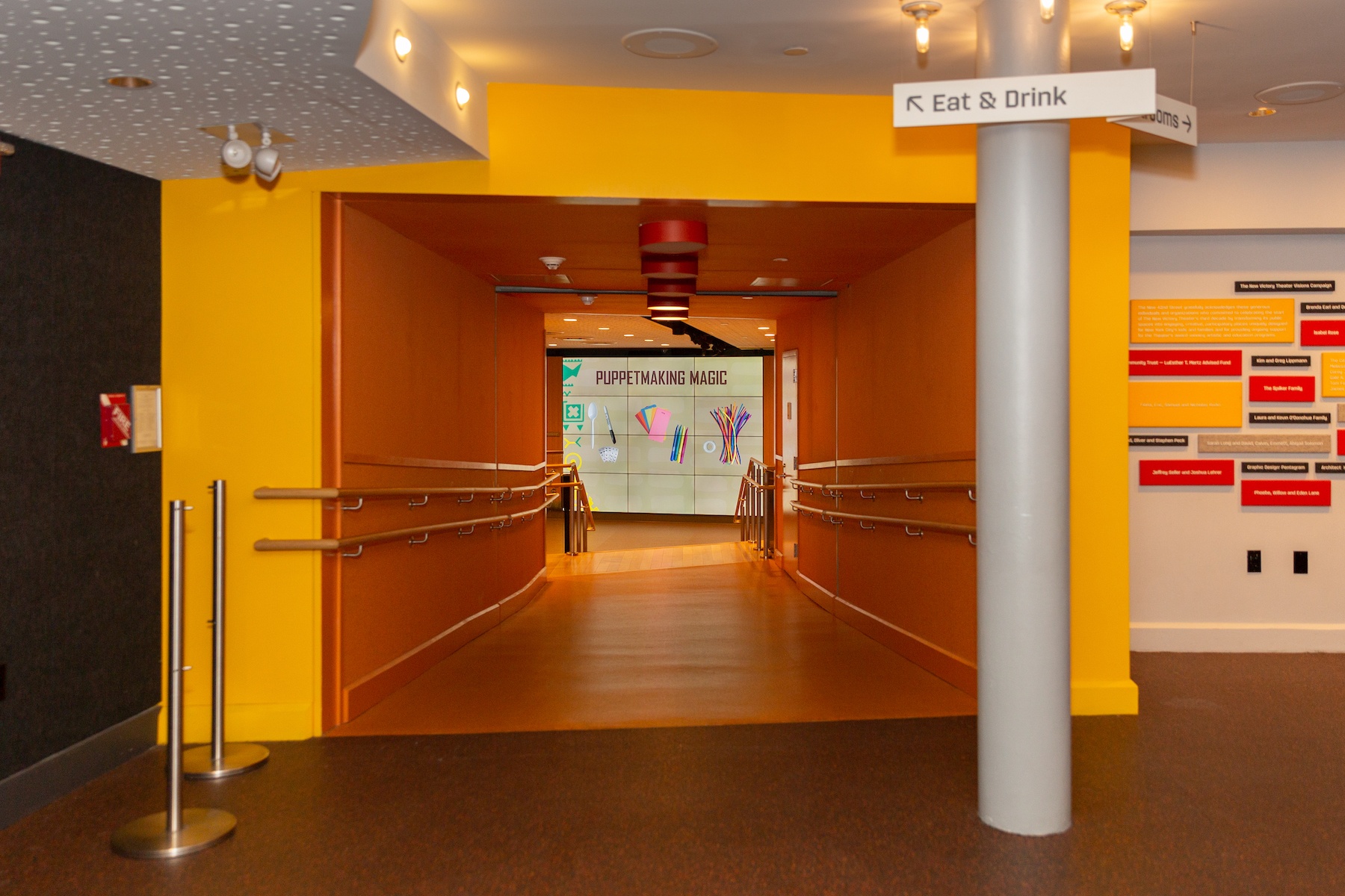 The orange tunnel to the Jack and Lew Rudin Lobby on the lower level of the New Victory Theater