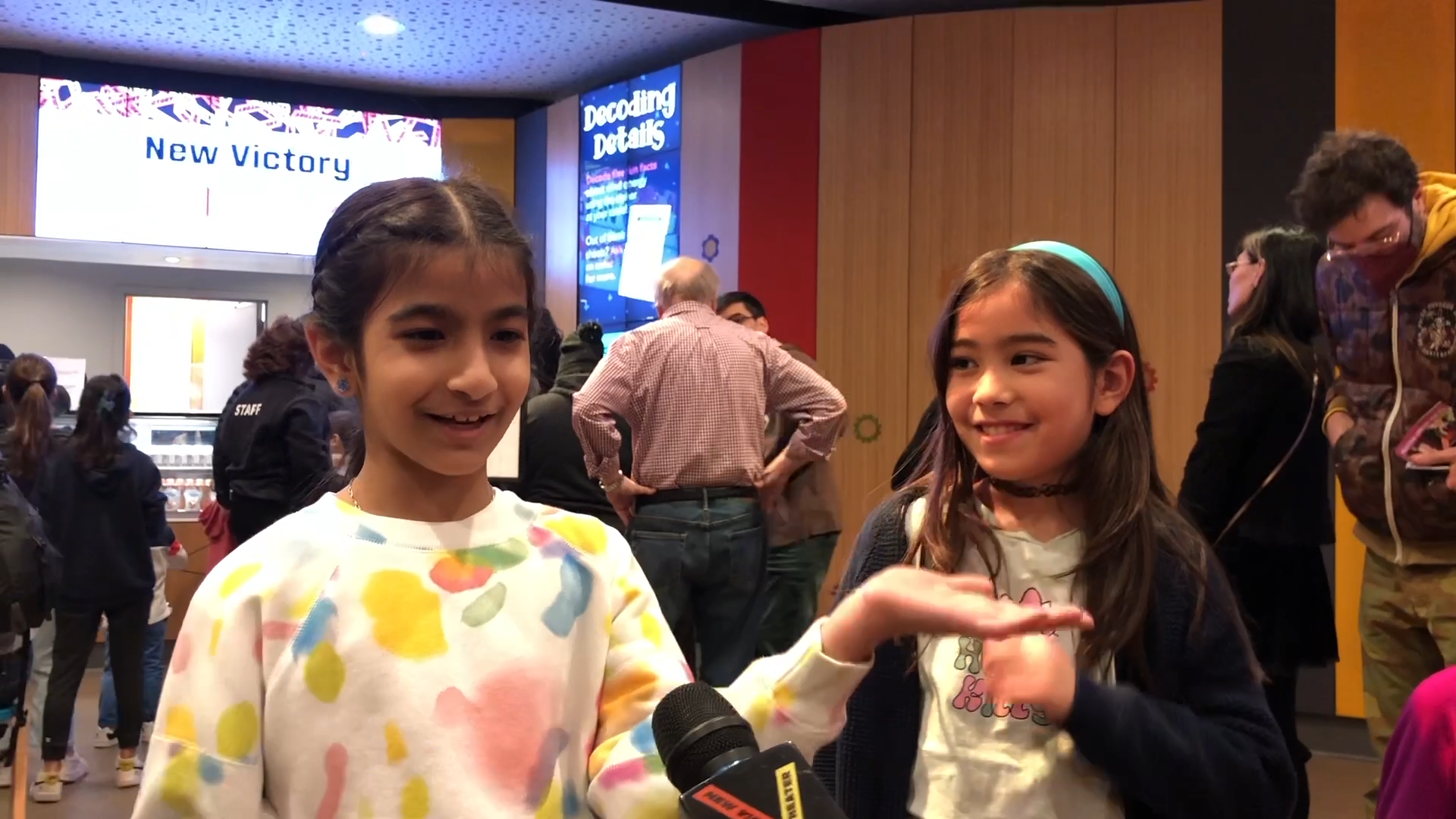 Two girls talk about the show Zephyr in the lobby of the New Victory Theater