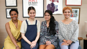 The four femme-identifying LabWorks Artists of the 2023-24 cohort sitting side by side and smiling at the camera
