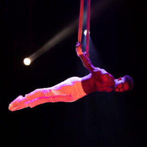 A circus performer swinging through the air.