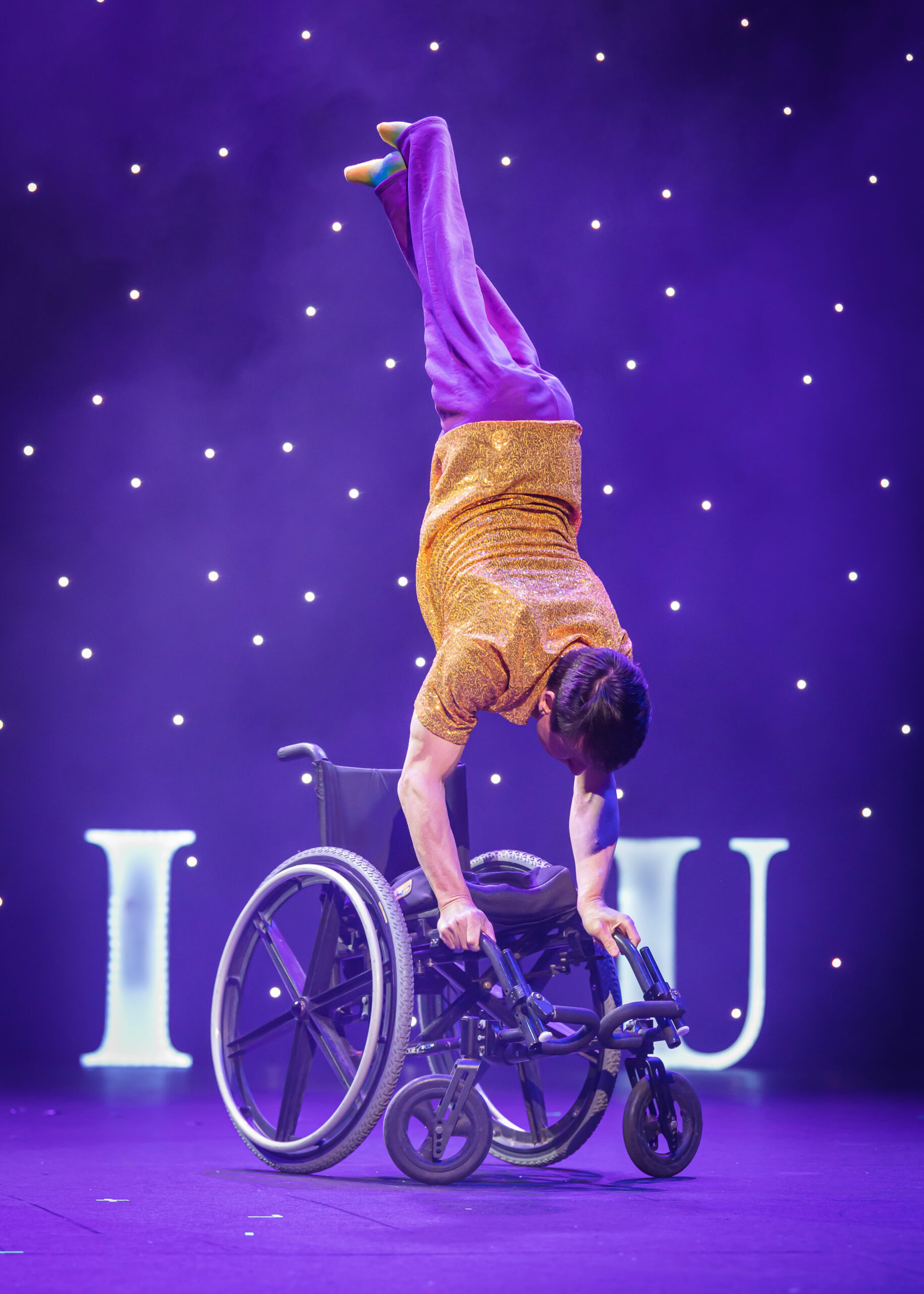 Rik Daniels does a handstand on his wheelchair.