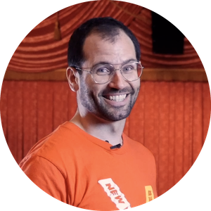 Headshot of Patrick Ferreri wearing an orange t-shirt with the New Victory Theater logo