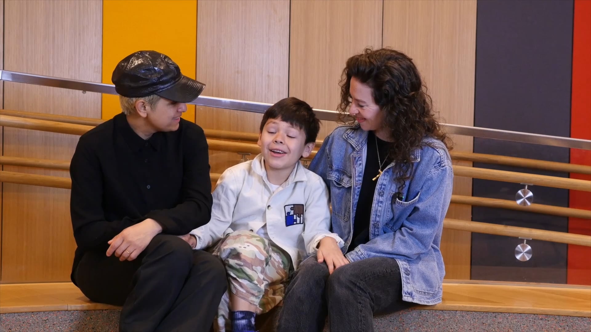 A kid sitting in the middle of their parents