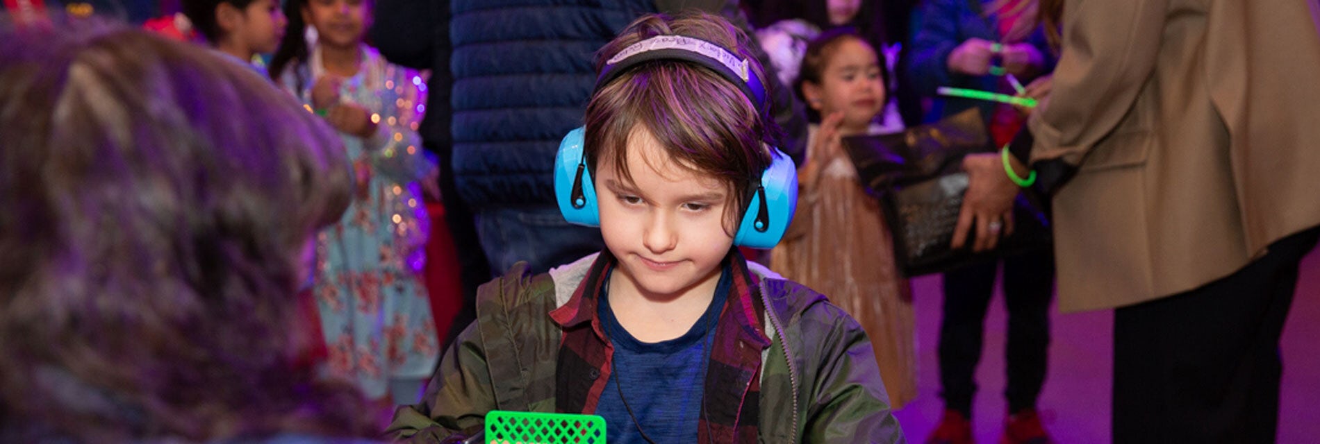 A young boy wearing blue ear defenders at the New Victory Theater.