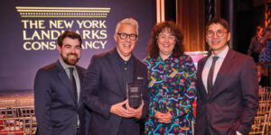 Four people holding the an award.