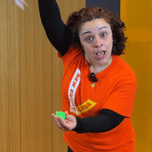 Looping GIF of Siobhan lowering a handkerchief over a green ping pong ball and vanishing it